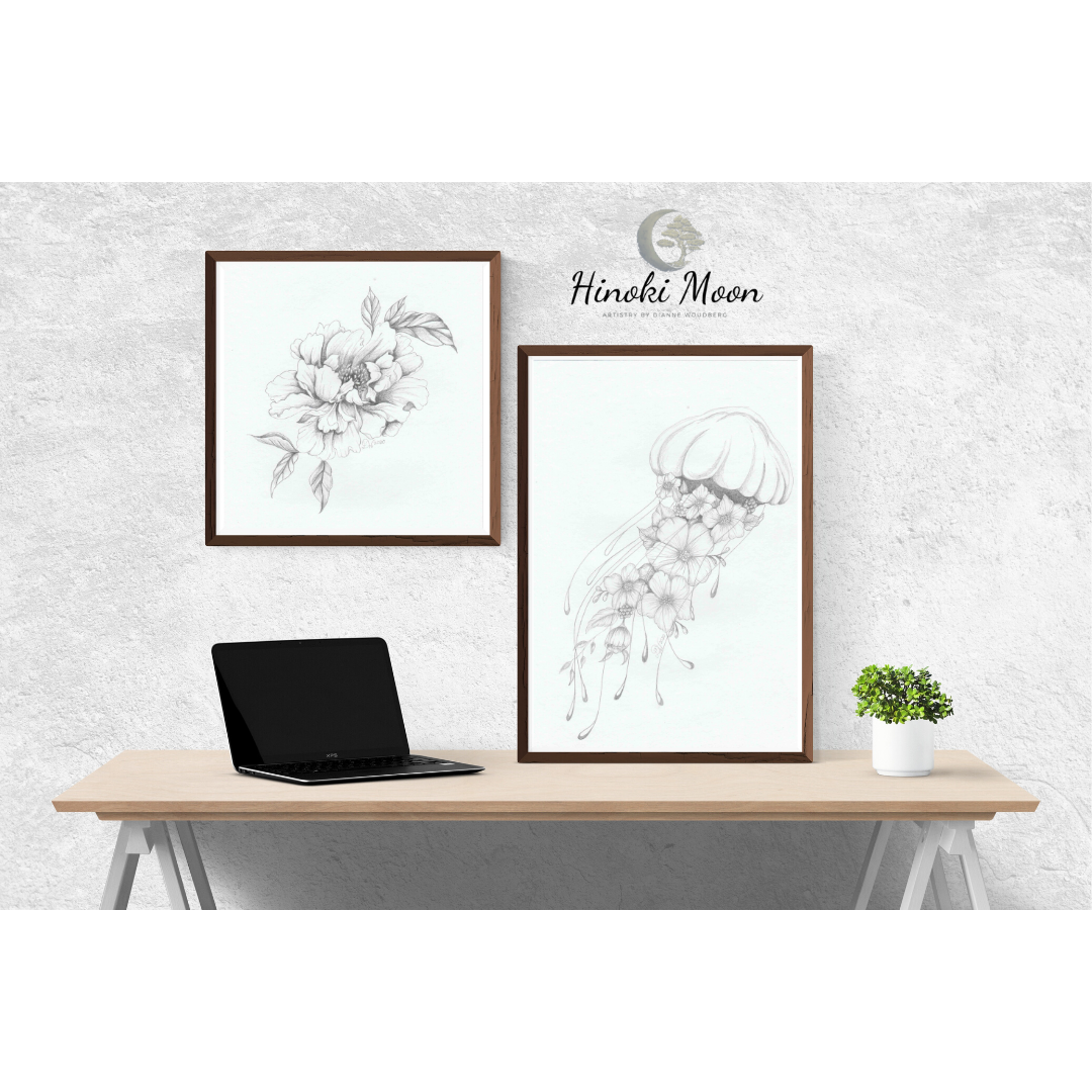 Desk with framed pencil drawings of a Peonie bloom and jellyfish with flowers.